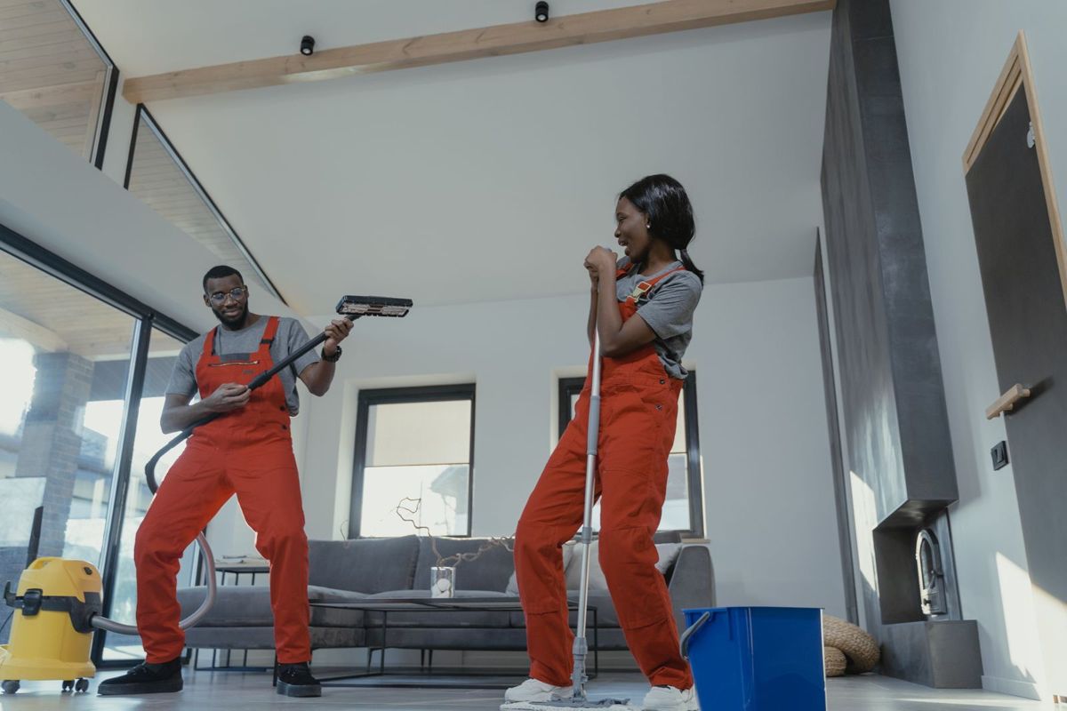 Cleaners vacuuming and mopping a bright living room